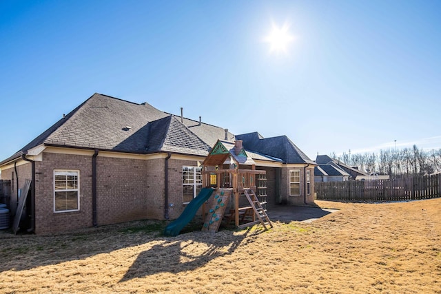 rear view of house featuring a playground