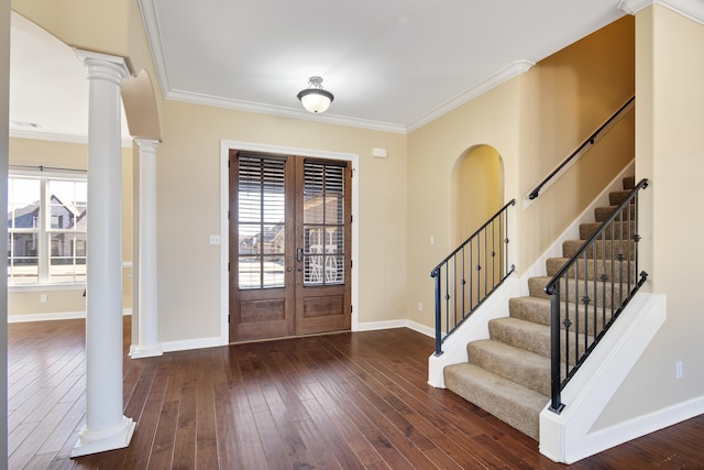 foyer with crown molding, dark wood-type flooring, and ornate columns