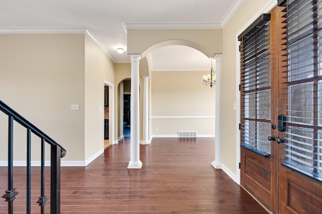 foyer entrance featuring dark wood-type flooring, french doors, crown molding, and a chandelier