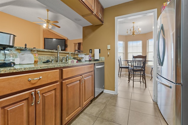 kitchen with light tile patterned floors, appliances with stainless steel finishes, a textured ceiling, ceiling fan with notable chandelier, and sink