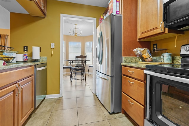 kitchen featuring light tile patterned floors, stainless steel appliances, and a chandelier