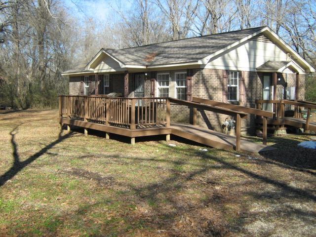 view of front of house with a front yard and a wooden deck