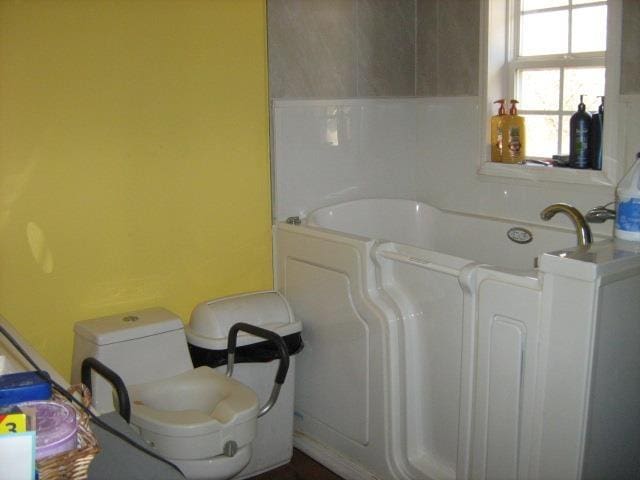 bathroom featuring toilet and a tub