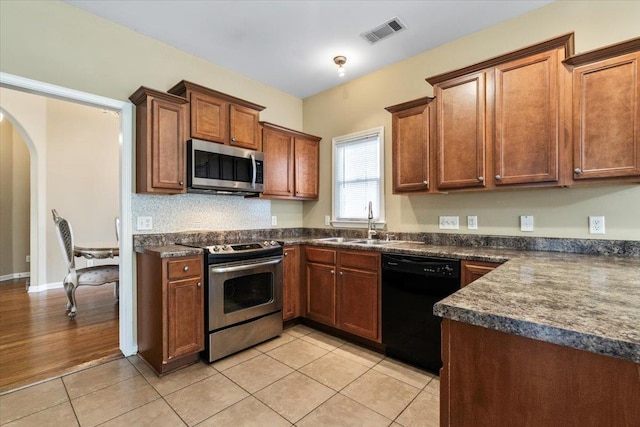 kitchen with light tile patterned floors, sink, and stainless steel appliances