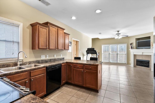 kitchen featuring ceiling fan, a fireplace, kitchen peninsula, sink, and black dishwasher