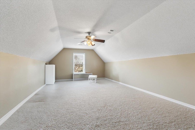 additional living space featuring ceiling fan, a textured ceiling, and lofted ceiling