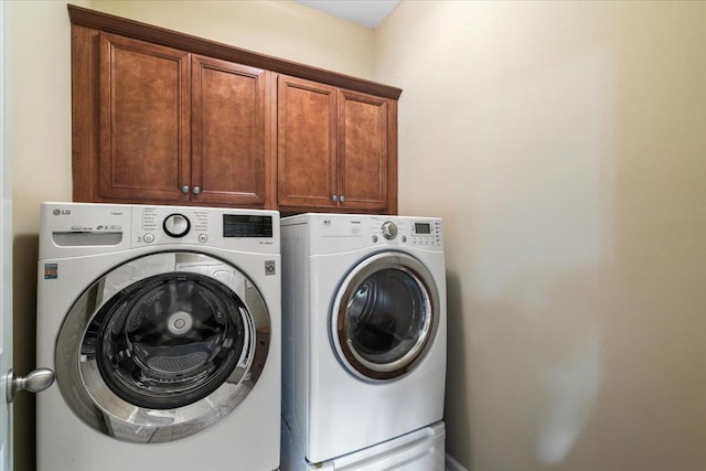 laundry room with cabinets and washer and clothes dryer