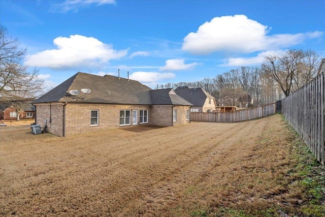 back of property with cooling unit and a lawn