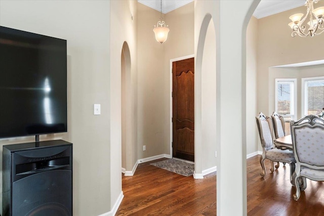 entrance foyer featuring dark hardwood / wood-style floors, a chandelier, and ornamental molding