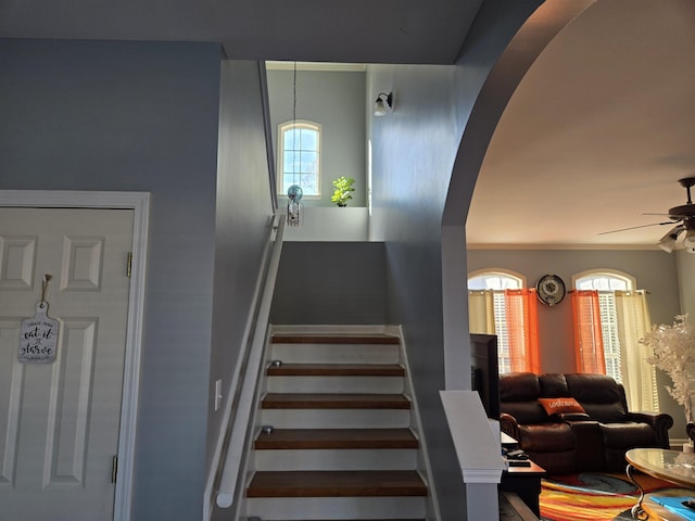 stairway featuring ceiling fan