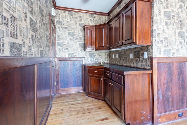 bar featuring light hardwood / wood-style floors, sink, and crown molding