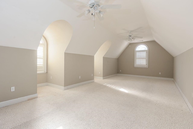 additional living space featuring light carpet, ceiling fan, and vaulted ceiling