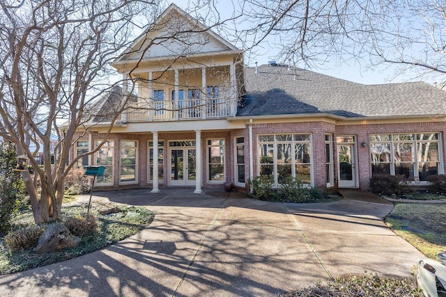 rear view of property with a balcony and french doors