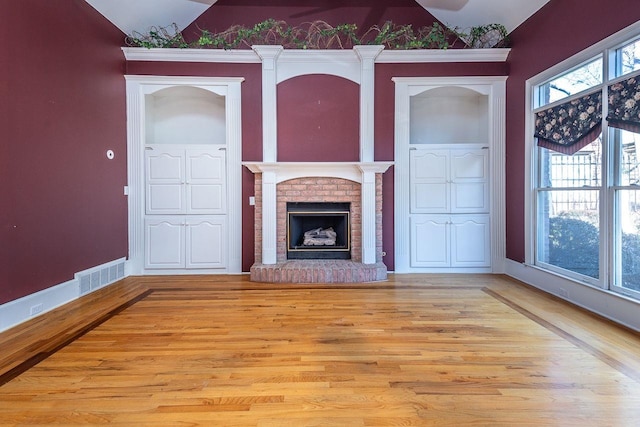 unfurnished living room featuring ornamental molding, light hardwood / wood-style floors, and a fireplace