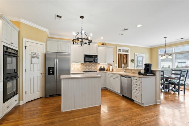 kitchen featuring black appliances, white cabinets, pendant lighting, and a kitchen island