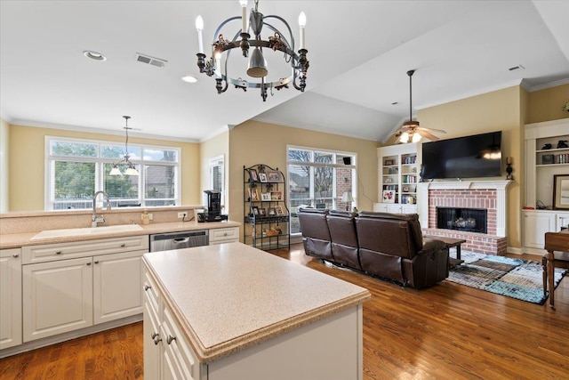 kitchen with a fireplace, hanging light fixtures, a healthy amount of sunlight, and a kitchen island