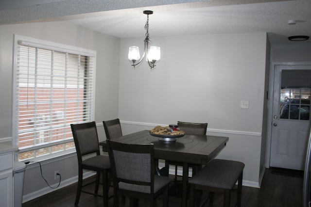 dining area featuring a notable chandelier and dark hardwood / wood-style floors