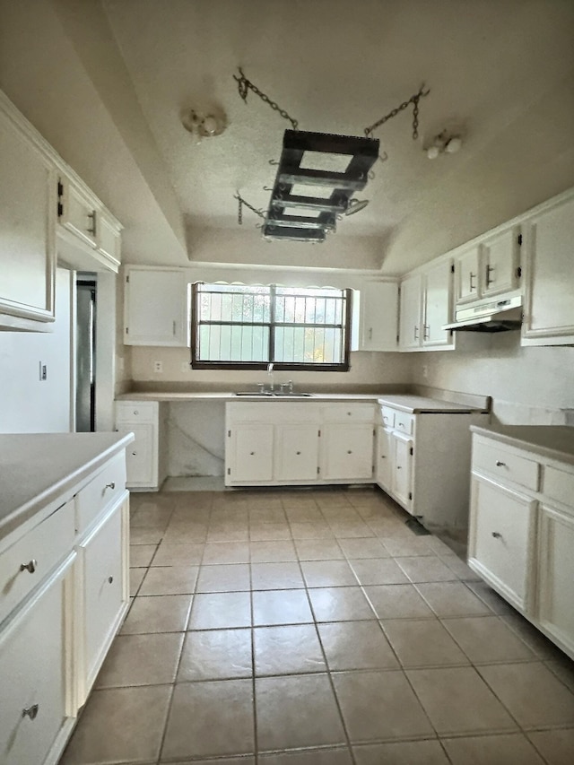 kitchen featuring light tile patterned floors and white cabinetry