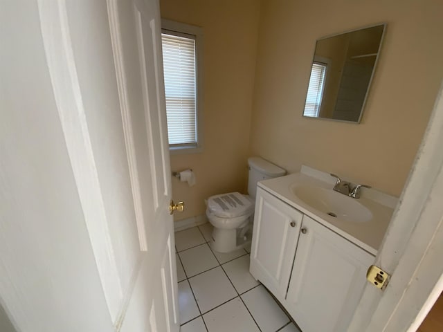 bathroom with toilet, vanity, and tile patterned flooring