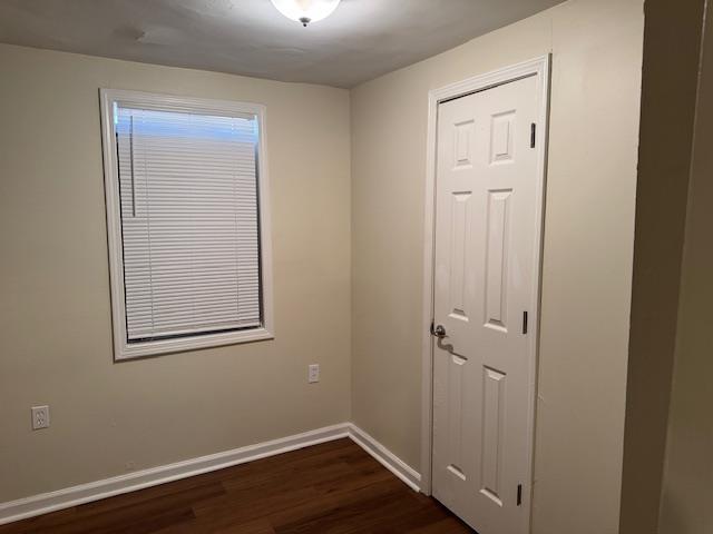 empty room with dark hardwood / wood-style flooring