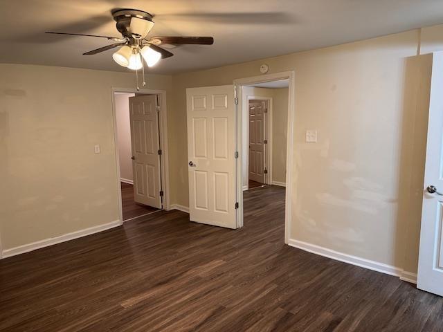 spare room featuring ceiling fan and dark wood-type flooring