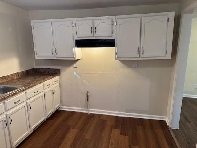 kitchen featuring dark wood-type flooring, white cabinetry, and extractor fan