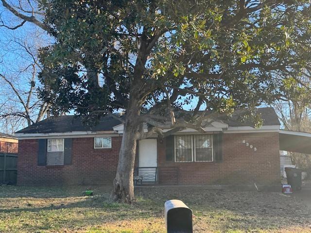 view of front of house with a front yard and a carport