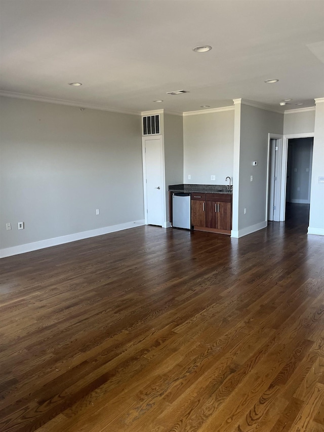 unfurnished living room featuring crown molding, dark hardwood / wood-style floors, and sink