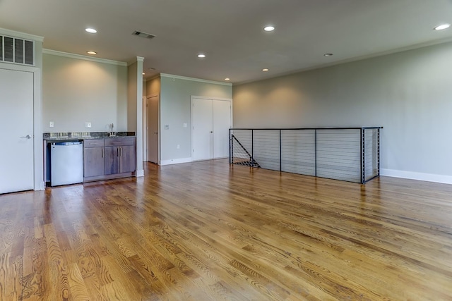 unfurnished living room with ornamental molding, light hardwood / wood-style floors, and sink