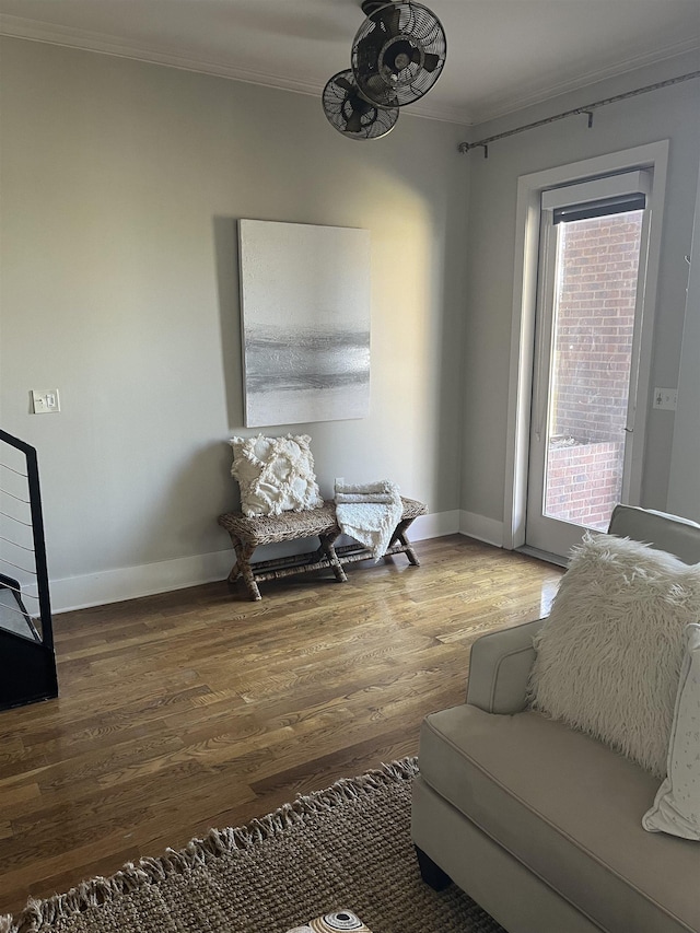 living area featuring hardwood / wood-style floors and crown molding