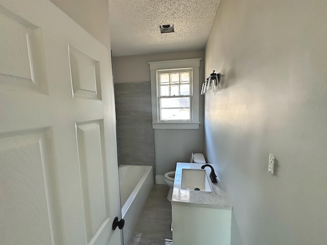 bathroom with toilet, vanity, and a textured ceiling