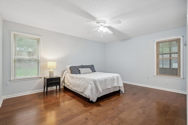 bedroom featuring a textured ceiling, ceiling fan, and dark hardwood / wood-style flooring