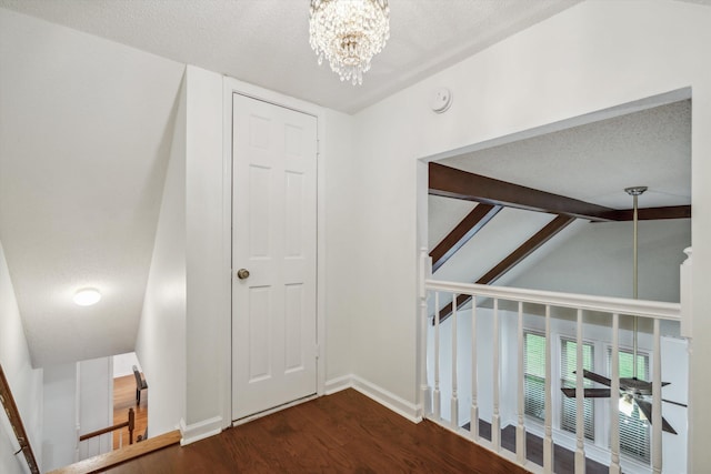 corridor with vaulted ceiling with beams, a notable chandelier, a textured ceiling, and dark hardwood / wood-style floors