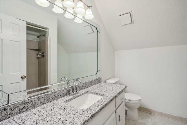 bathroom featuring toilet, vanity, tile patterned flooring, vaulted ceiling, and tiled shower