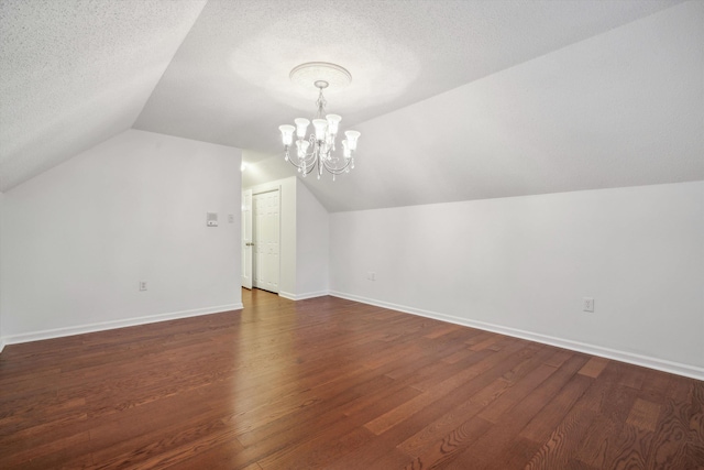 bonus room featuring dark wood-type flooring, a textured ceiling, and lofted ceiling