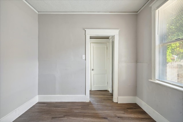 spare room with dark hardwood / wood-style flooring, ornamental molding, and a textured ceiling