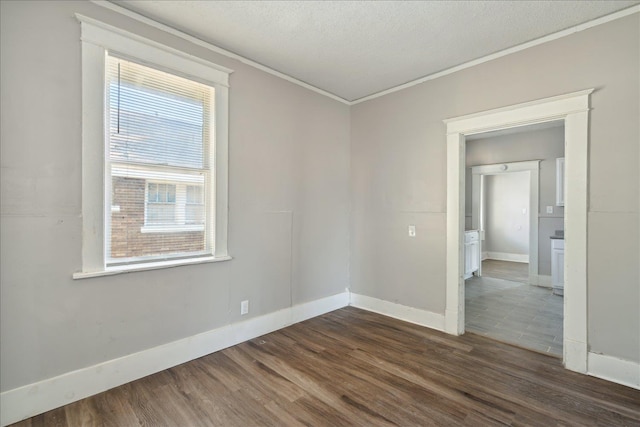 empty room with dark wood-type flooring, a textured ceiling, and crown molding