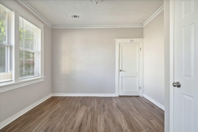 unfurnished room featuring hardwood / wood-style flooring, a textured ceiling, and crown molding