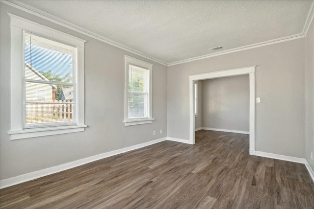 empty room featuring a textured ceiling, dark hardwood / wood-style floors, crown molding, and a healthy amount of sunlight