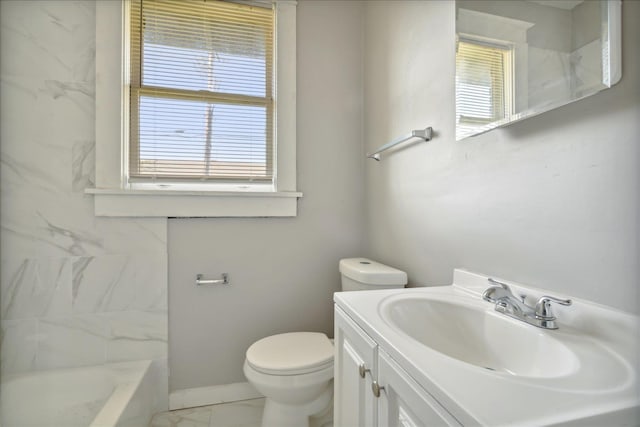 bathroom featuring toilet, vanity, and plenty of natural light