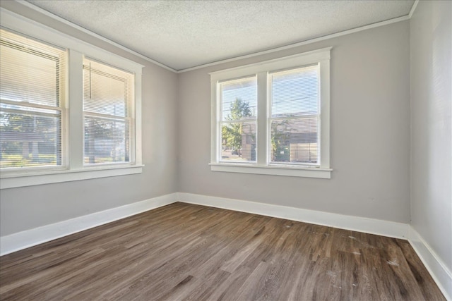 empty room with a textured ceiling, dark hardwood / wood-style flooring, and ornamental molding