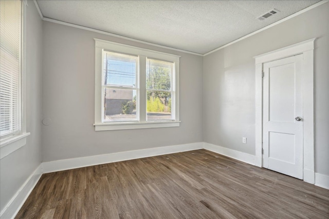 empty room featuring dark hardwood / wood-style flooring, crown molding, and a textured ceiling