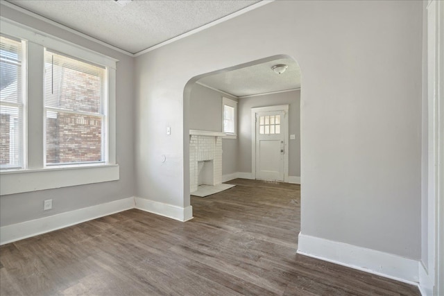 foyer featuring a wealth of natural light, a textured ceiling, dark hardwood / wood-style flooring, and ornamental molding