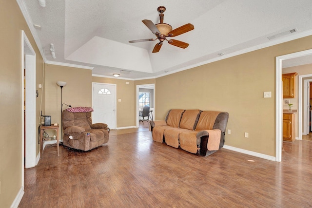 living room featuring ceiling fan, a tray ceiling, wood-type flooring, a textured ceiling, and crown molding