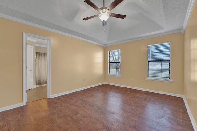 empty room with hardwood / wood-style floors, crown molding, and a raised ceiling