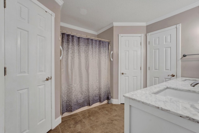 bathroom featuring a textured ceiling, vanity, ornamental molding, and tile patterned flooring