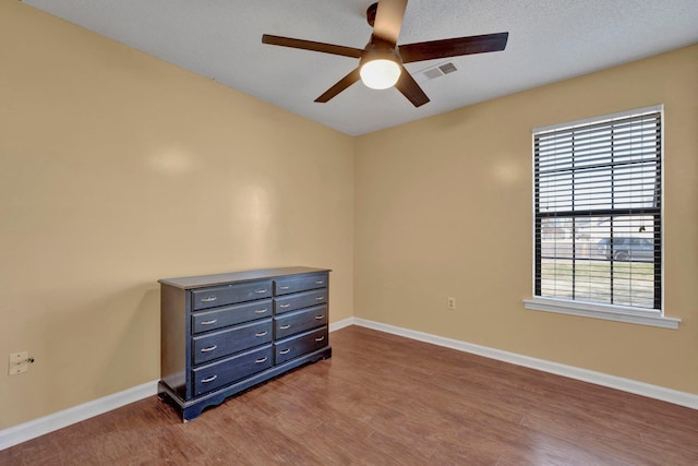 bedroom with ceiling fan, hardwood / wood-style flooring, and multiple windows