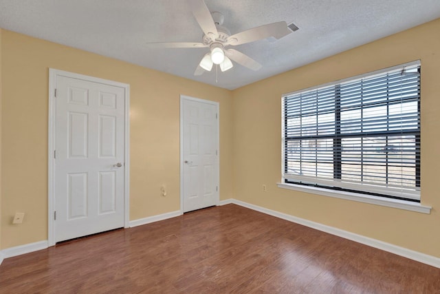 unfurnished bedroom featuring ceiling fan, a textured ceiling, and hardwood / wood-style flooring