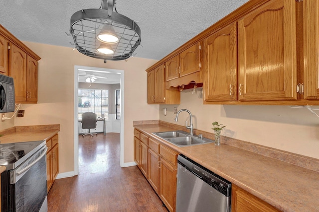 kitchen with ceiling fan, appliances with stainless steel finishes, dark hardwood / wood-style flooring, and sink