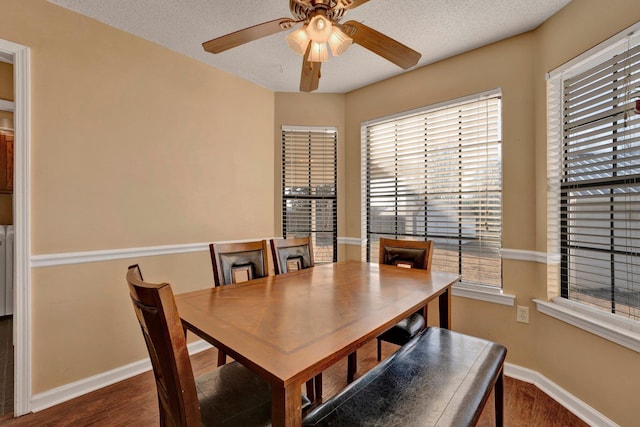 dining space with ceiling fan, dark hardwood / wood-style flooring, and a textured ceiling